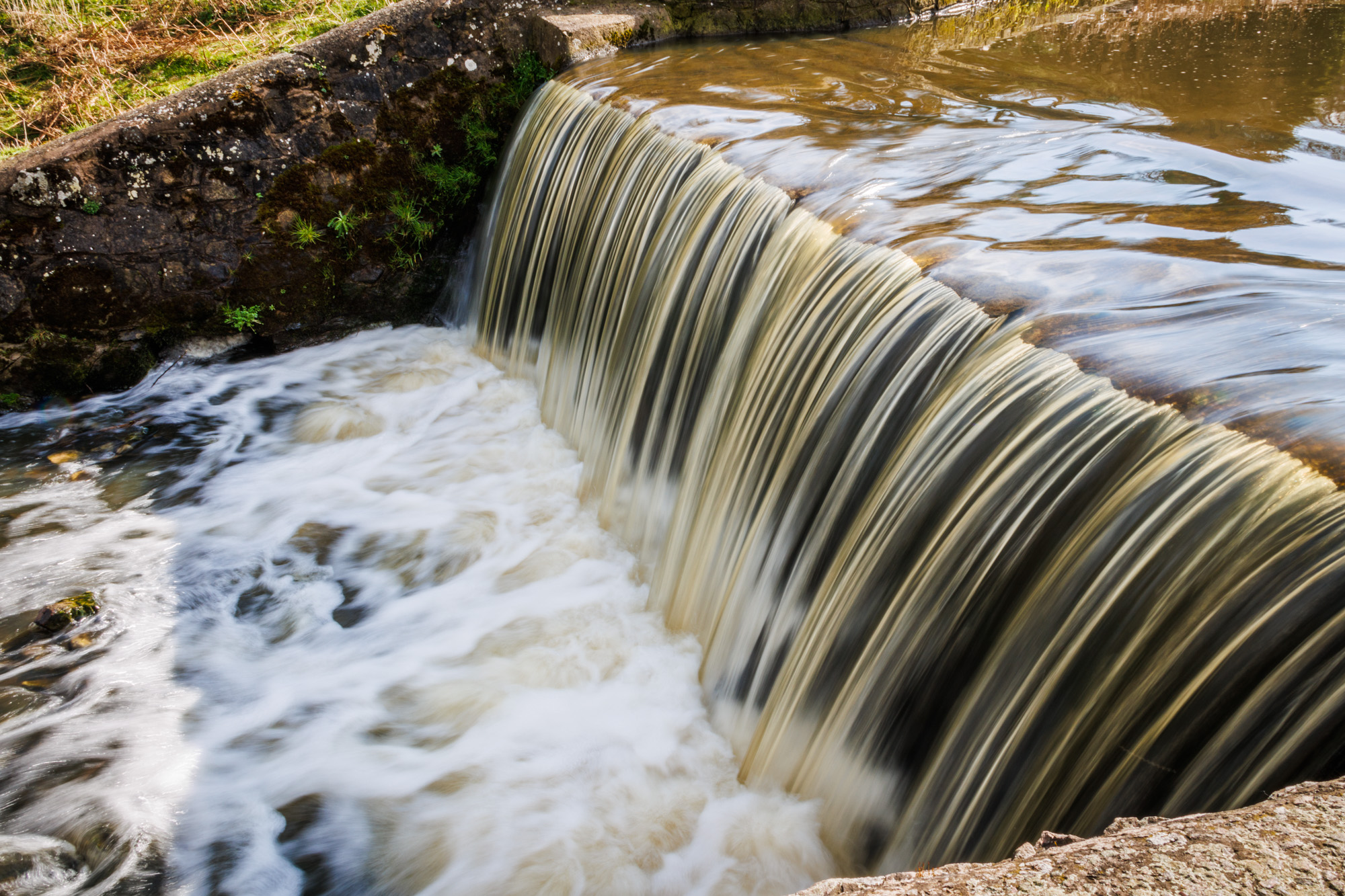 A smooth river running over a small waterfall