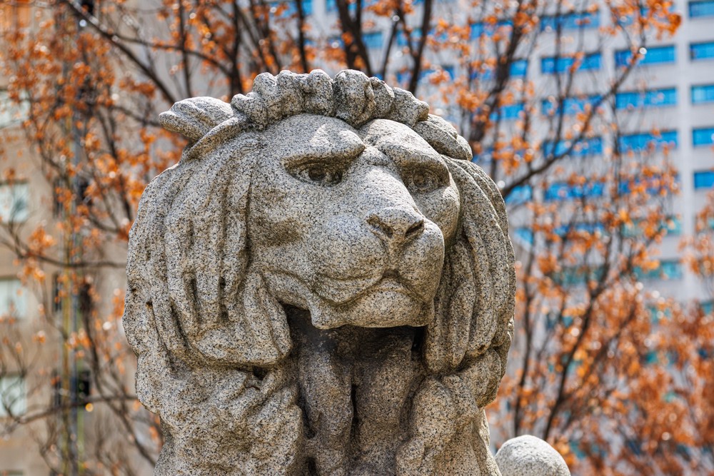 A grey stone statue of a lion