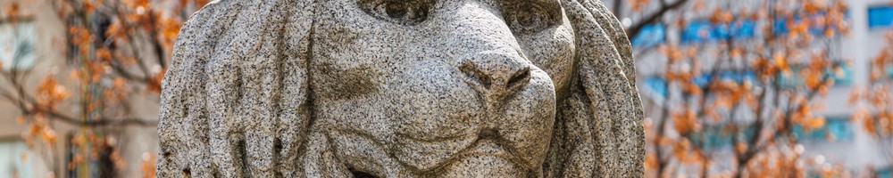 A grey stone statue of a lion